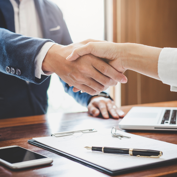 New business owner shaking hands with a business broker after closing on a business purchase