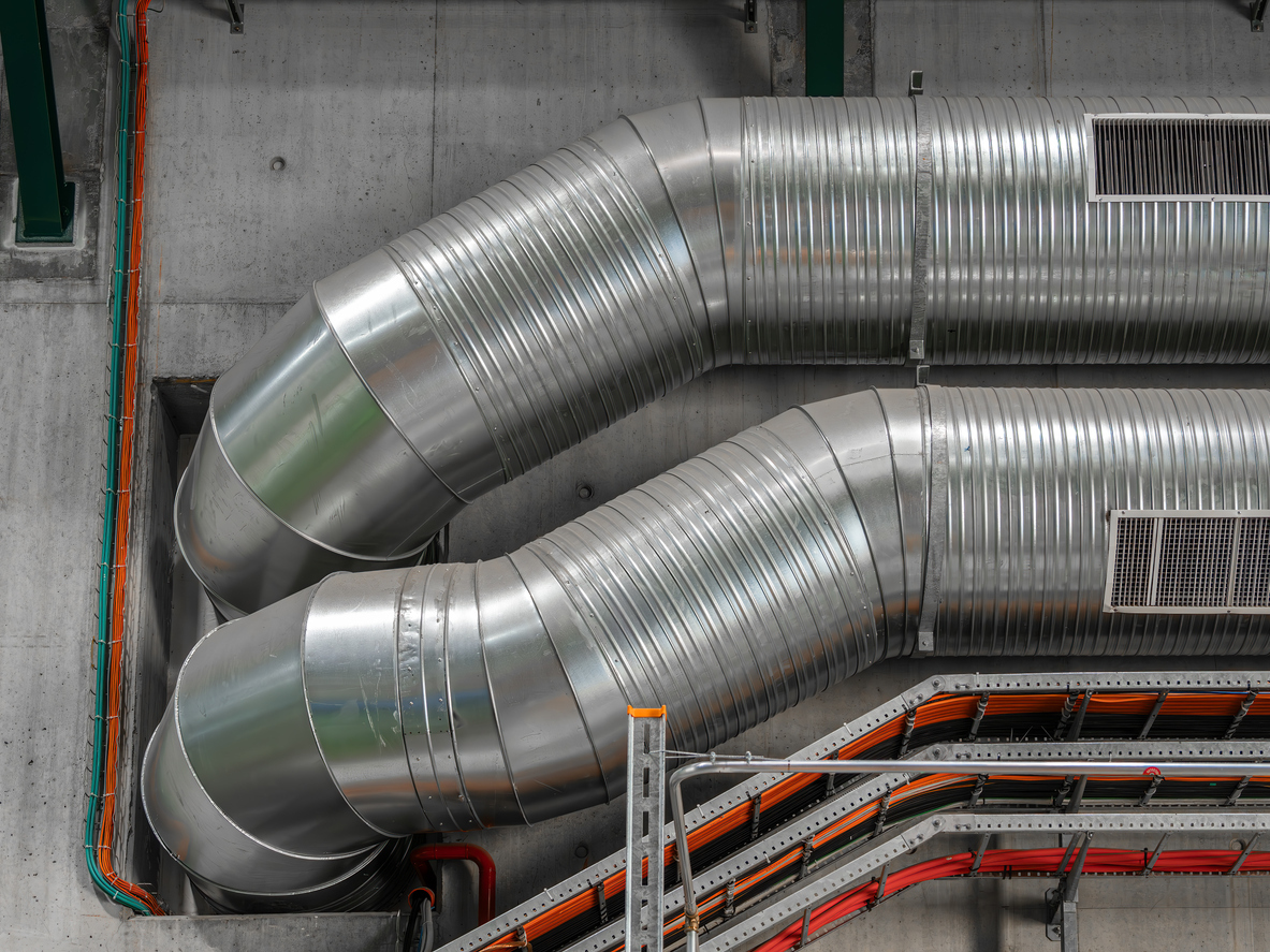 Industrial ventilation ducts and exhaust system installed inside a factory for air circulation and workplace safety.
